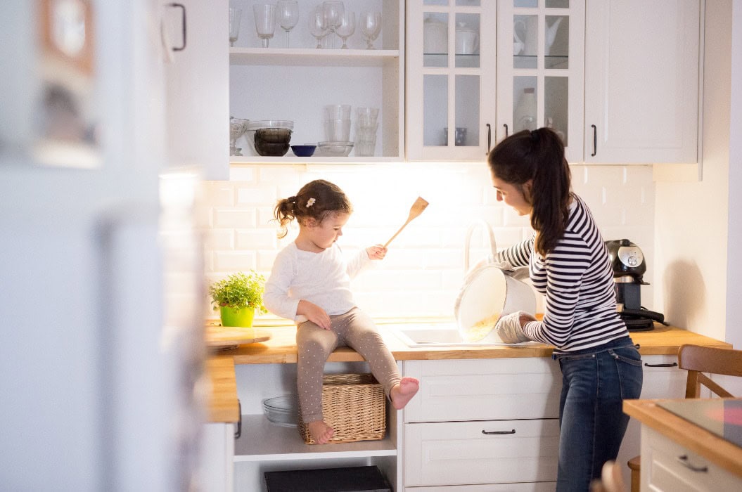 Mutter mit ihrer Tochter in der Küche beim gemeinsamen Kochen